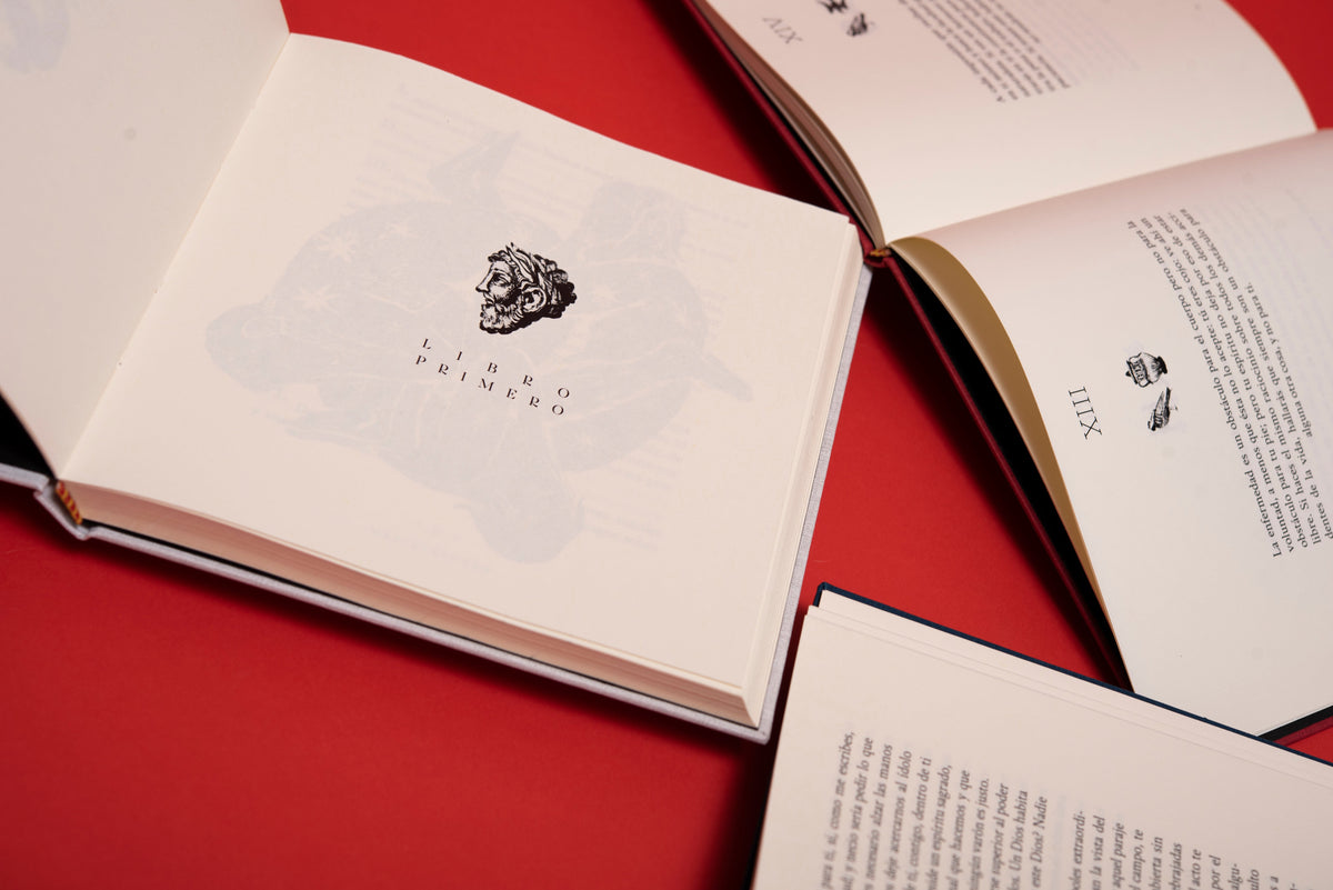 Páginas interiores sobre fondo rojo: la portadilla del Libro Primero de «Meditaciones», con un grabado de cabeza barbada.