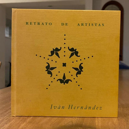 Ejemplar de tapa dura en tela amarilla sobre una mesa de madera, con el título y la roseta estampados en verde oscuro.